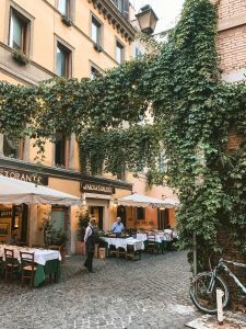 Charming cafe with ivy-covered facade and outdoor seating in Rome, Italy.